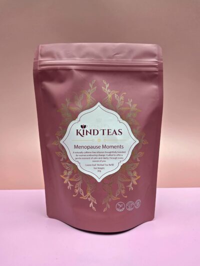 Purple tea bag pouch labeled KIND TEAS, Menopause Moments, with gold floral design and a white badge in the center showing the product name and details.