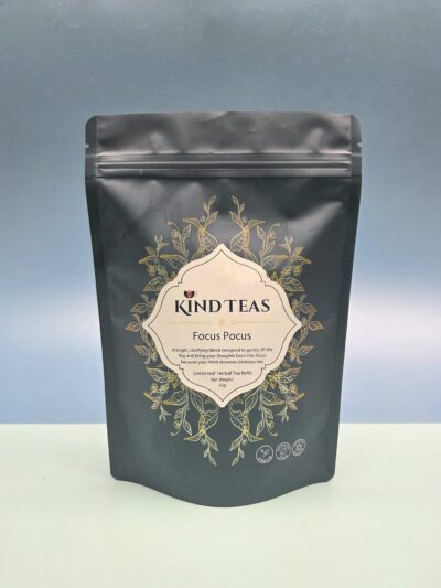 Black stand-up tea pouch with gold ornamental design and a cream label reading "KIND TEAS Focus Focus" (loose-leaf herbal tea).