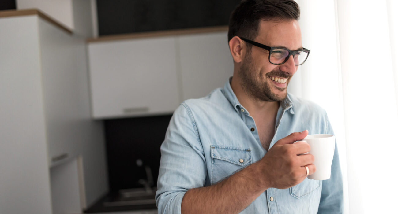 Handsome man having cup of coffee at home in the morning