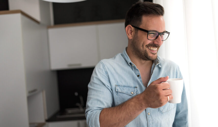 Handsome man having cup of coffee at home in the morning