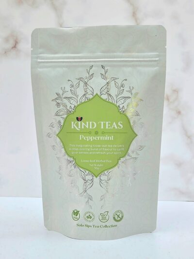 Packaging for Kind Teas Peppermint loose-leaf tea with green label and decorative vines on a pale background